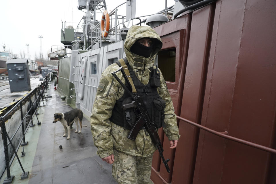 A Ukrainian serviceman with his dog stands on board a coast guard ship in the Sea of Azov port of Mariupol, eastern Ukraine, Monday, Dec. 3, 2018. The Ukrainian military has been on increased readiness as part of martial law introduced in the country in the wake of the Nov. 25, 2018 incident in the Sea of Azov, in which the Russian coast guard fired upon and seized three Ukrainian navy vessels along with their crews. (AP Photo/Evgeniy Maloletka)