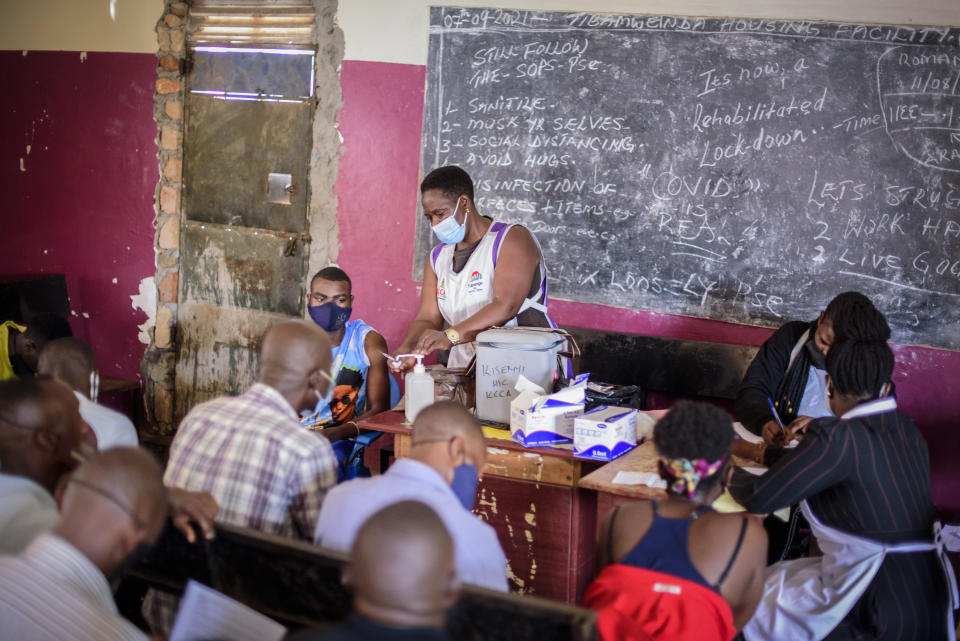 A nurse administers a coronavirus vaccination at Kisenyi Health Center in downtown Kampala, Uganda Wednesday, Sept. 8, 2021. Uganda is accelerating its vaccination drive in order to administer 128,000 doses that recently arrived and expire at the end of September. (AP Photo/Nicholas Bamulanzeki)