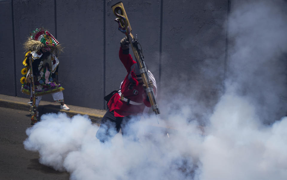 A man fires a muzzleloader gun during the re-enactment of The Battle of Puebla as part of Cinco de Mayo celebrations in the Peñon de los Baños neighborhood of Mexico City, Thursday, May 5, 2022. Cinco de Mayo commemorates the victory of an ill-equipped Mexican army over French troops in Puebla on May 5, 1862. (AP Photo/Eduardo Verdugo)