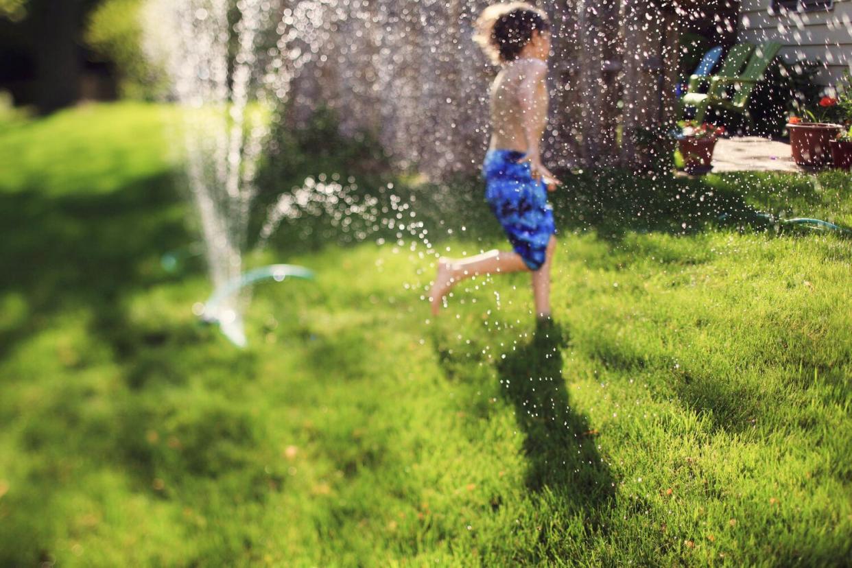 boy playing in sprinkler