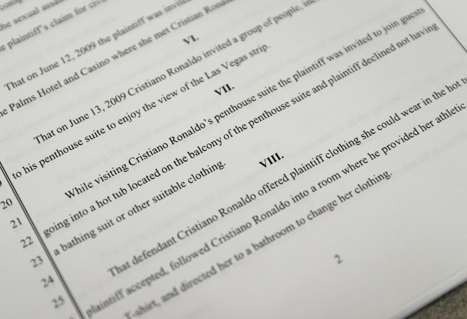 FILE - In this Oct. 1, 2018 file photo, a court document lays out allegations against Cristiano Ronaldo in Las Vegas. A Nevada woman's lawsuit claiming that Cristiano Ronaldo raped her nine years ago and paid her $375,000 in hush money has set in motion a two-track legal process that could put the fate of one of the world's most famous athletes in the hands of Nevada jurors who may or may not know about the soccer star's fame. Whether criminal charges are filed depends on the outcome of a police investigation reopened last month at the request of Kathryn Mayorga, a former model who alleges that Ronaldo attacked her in the bedroom of his penthouse at a Las Vegas hotel in 2009. (AP Photo/John Locher, File)