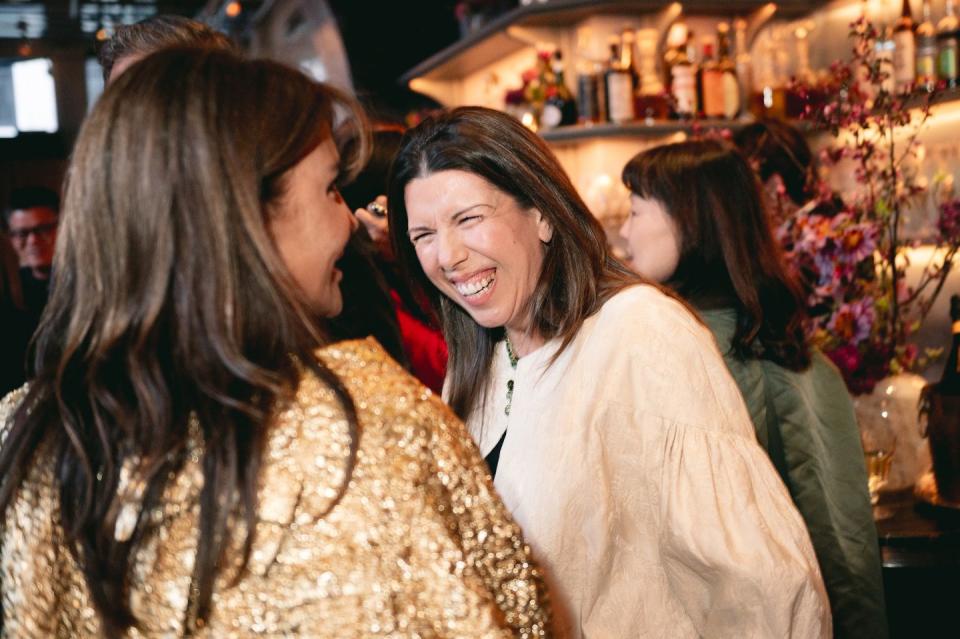 a person kissing another woman's cheek