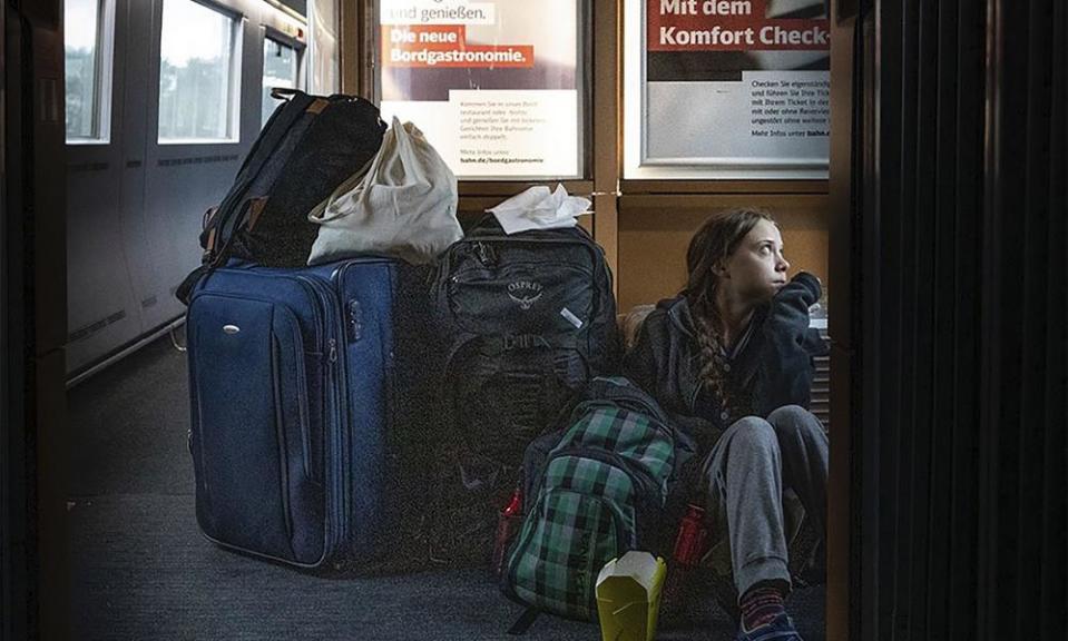 Greta Thunberg sits on the floor during her train journey home.