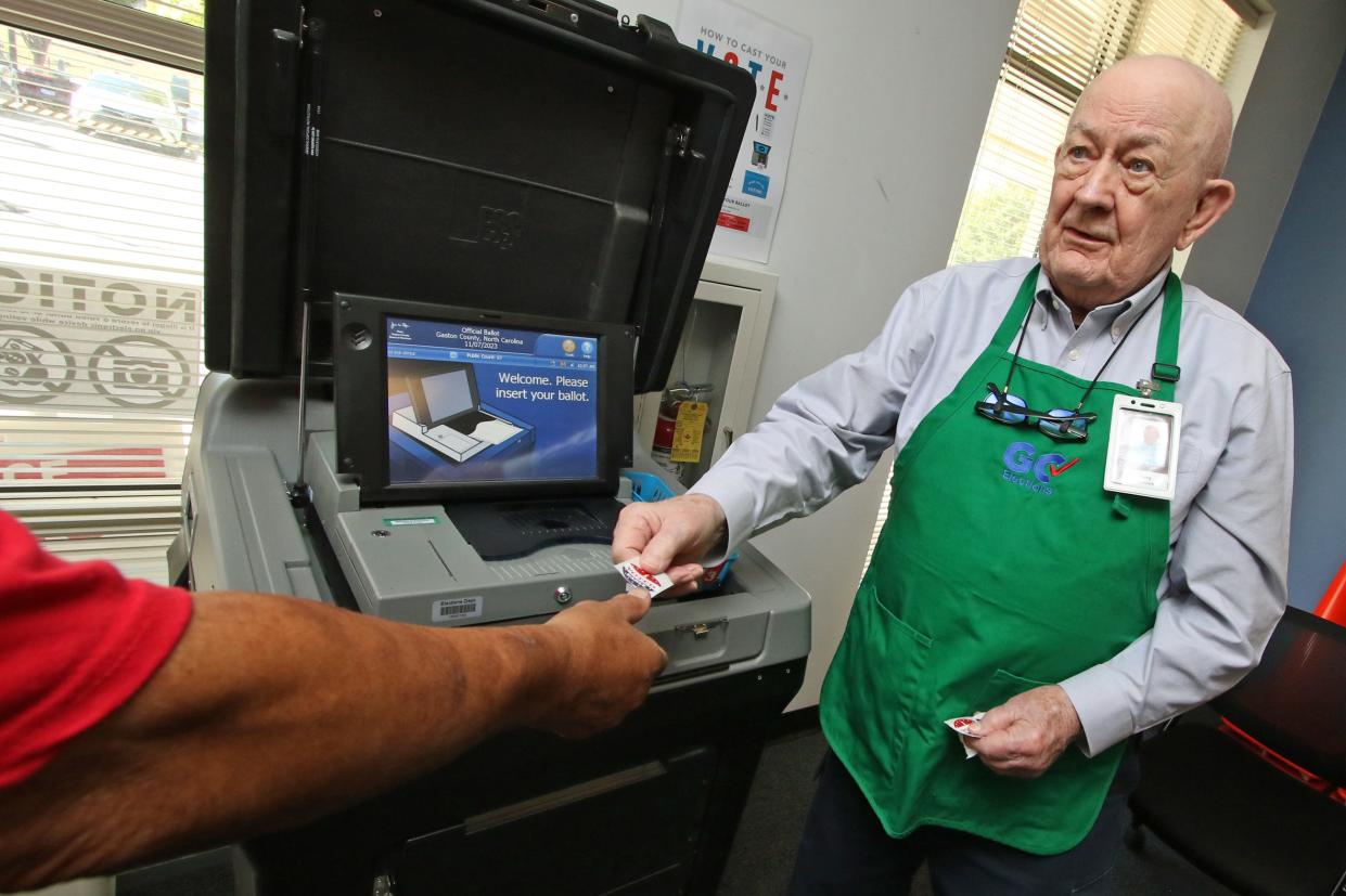 Jerry Willhauck hands out stickers to those who vote as early voting has begun in Gaston County at the Gaston County Board of Elections on West Franklin Boulevard Thursday morning, Oct. 19, 2023.