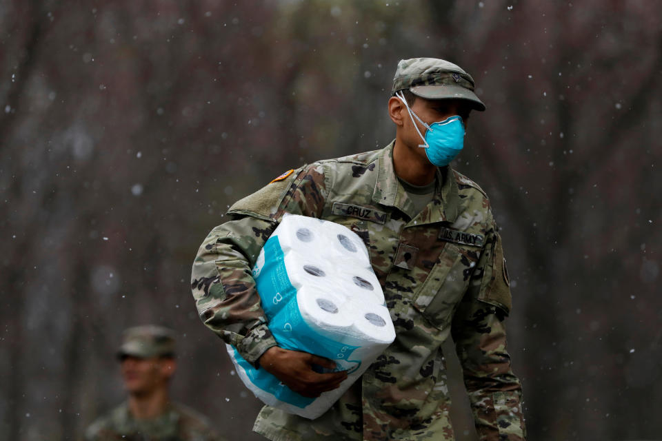 A member of Joint Task Force 2, composed of soldiers and airmen from the New York Army and Air National Guard, wears a face mask while carrying paper towels as he arrives to sanitize and disinfect the Young Israel of New Rochelle synagogue, as snow falls during the coronavirus disease (COVID-19) outbreak in New Rochelle, New York, U.S., March 23, 2020. REUTERS/Andrew Kelly     TPX IMAGES OF THE DAY