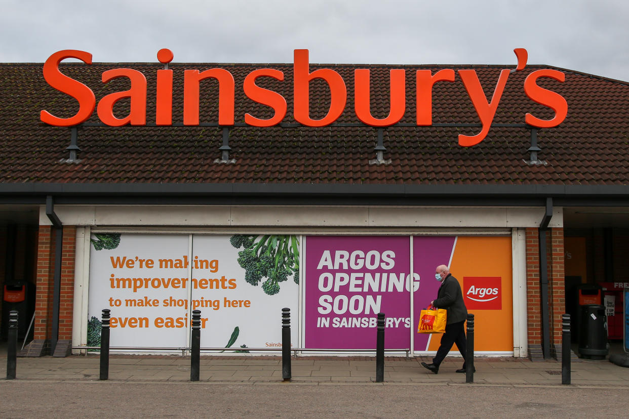 Sainsbury’s LONDON, UNITED KINGDOM - 2021/03/05: An elderly man wearing a face mask as a precaution against the spread of covid-19 walks past 'Argos Opening Soon' sign displayed in a window of Sainsbury's superstore in London. (Photo by Dinendra Haria/SOPA Images/LightRocket via Getty Images)