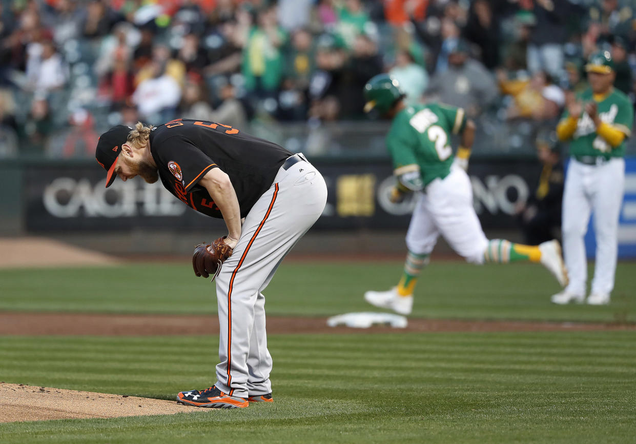 Baltimore Orioles starting pitcher Andrew Cashner stand at the edge of the mound as Oakland Athletics' Khris Davis (2) circles the bases on a three-run home run during the first inning of a baseball game Friday, May 4, 2018, in Oakland, Calif. (AP Photo/Tony Avelar)