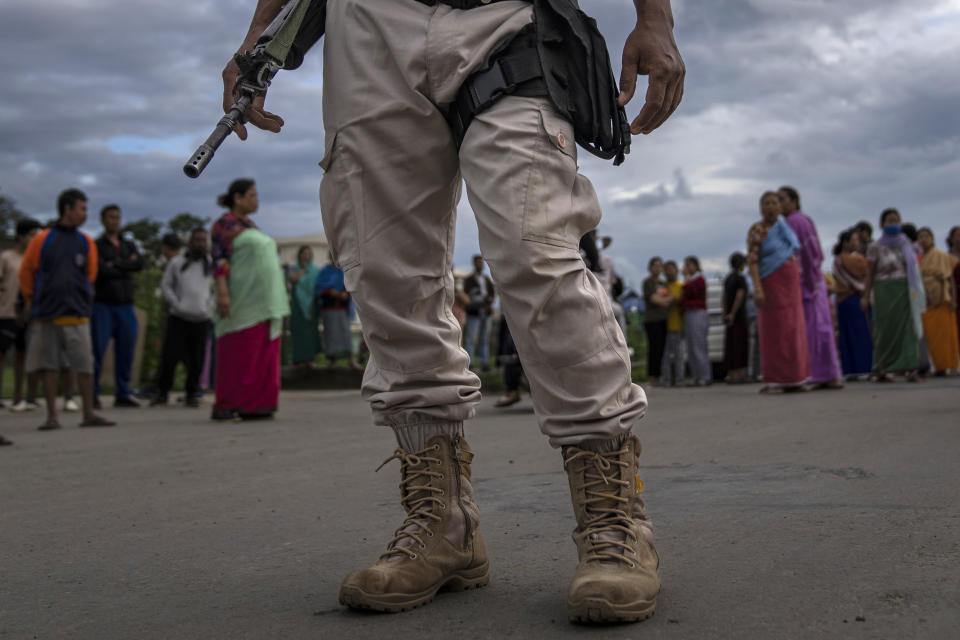 A Manipur policeman stands guard as members of Meira Paibis, powerful vigilante group of Hindu majority Meitei women, block traffic to check vehicles for members from rival tribal Kuki community, in Imphal, capital of the northeastern Indian state of Manipur, Monday, June 19, 2023. India’s prime minister Narendra Modi Thursday, July 20, broke more than two months of his public silence over the deadly ethnic clashes that have marred the country's remote northeast Manipur state, a day after a viral video showed two women being paraded naked by a mob, sparking outrage across the nation. (AP Photo/Altaf Qadri)