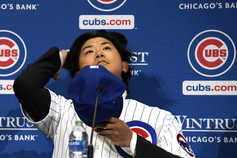 New Chicago Cubs pitcher Shōta Imanaga puts on his cap during a news conference Friday, Jan. 12, 2024, in Chicago. The Japanese left-hander is expected to step right into the baseball team's rotation as it tries to return to the playoffs for the first time since 2020. (AP Photo/Nam Y. Huh)