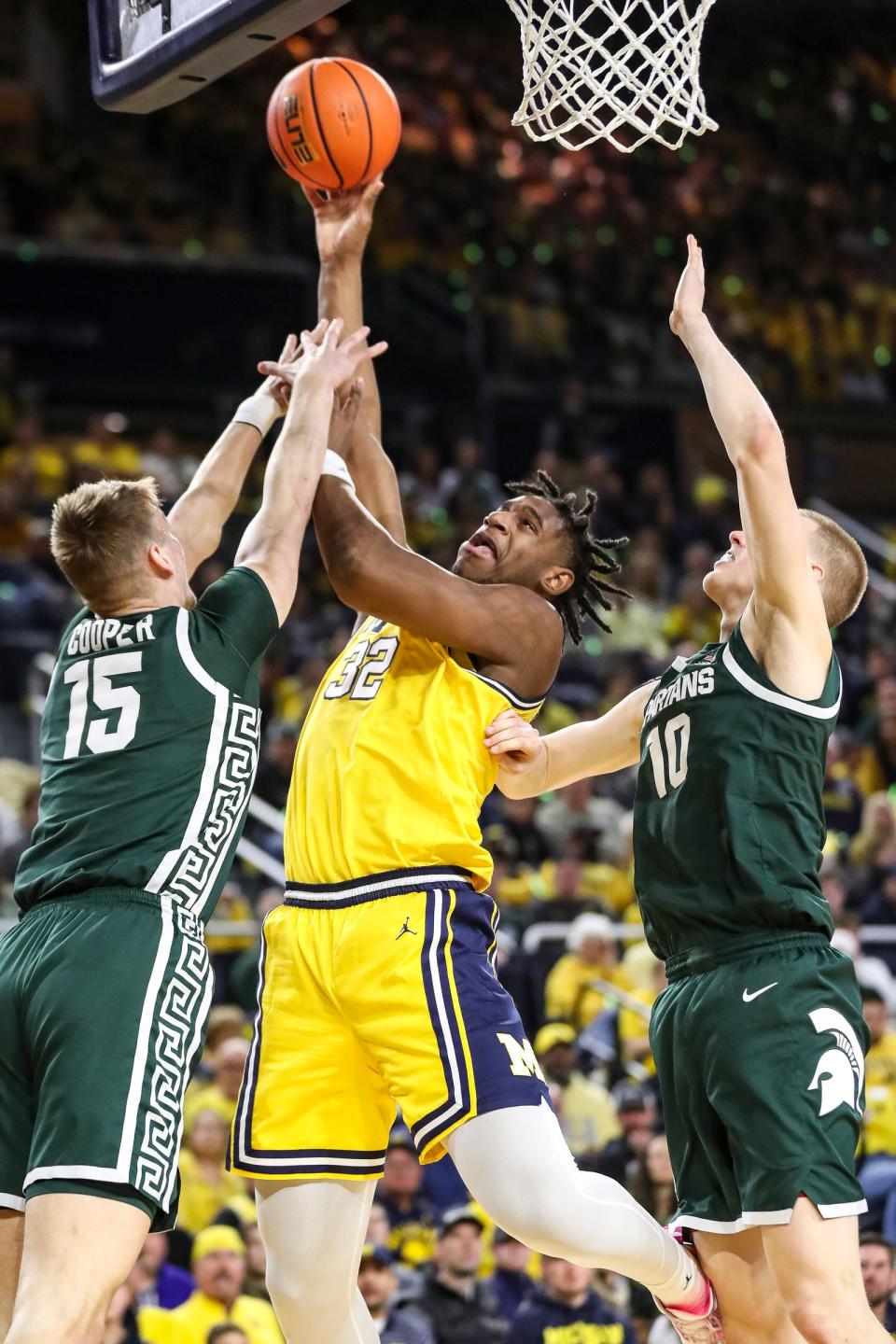 Michigan forward Tarris Reed Jr. (32) goes to the basket against Michigan State center Carson Cooper (15) and forward Joey Hauser (10) during the first half at Crisler Center in Ann Arbor on Saturday, Feb. 18, 2023.