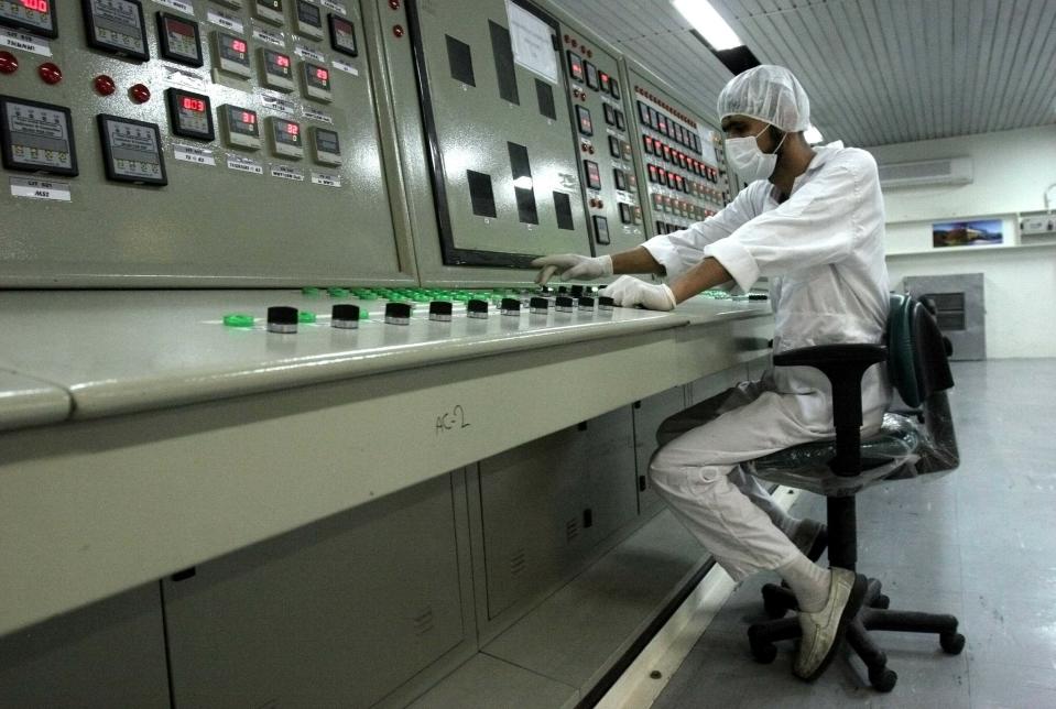 FILE - In this Feb. 3, 2007 file photo, an Iranian technician works at the Uranium Conversion Facility just outside the city of Isfahan, Iran, 255 miles (410 kilometers) south of the capital Tehran. On Monday, June 17, 2019, Iran said it will break the uranium stockpile limit set by Tehran's nuclear deal with world powers in the next 10 days. (AP Photo/Vahid Salemi, File)