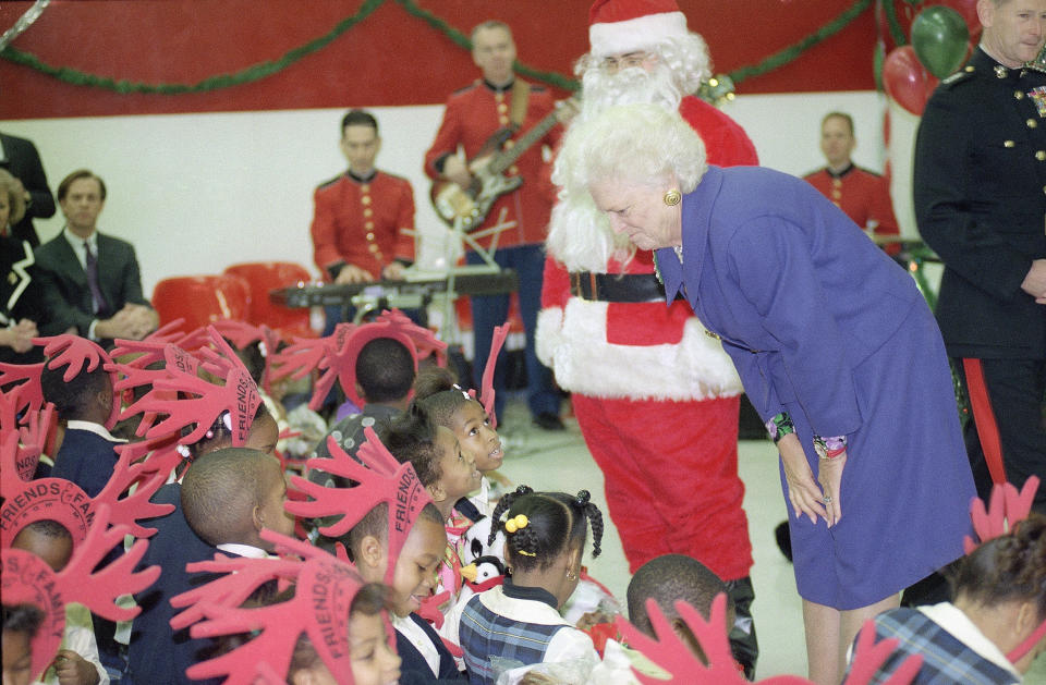 First Lady Barbara Bush, right, at a Toys for Tots Christmas party at the Metropolitan Police Boys and Girls Club, Wednesday, Dec. 9, 1992, Washington, D.C. Later she read a story to the Benning Elementary school kids. The rest of the group is unidentified. (AP Photo/Barry Thumma)