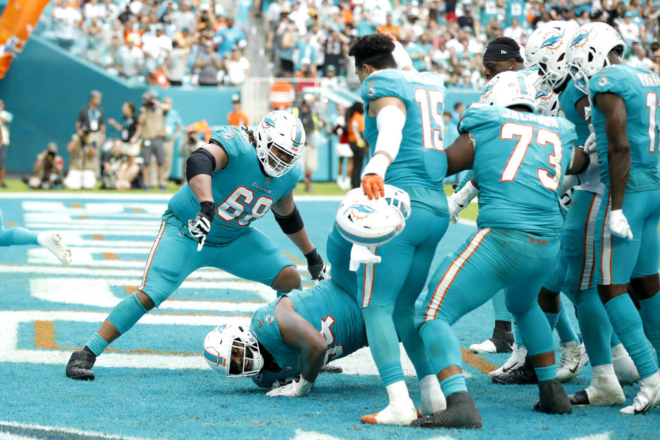 Christian Wilkins and Miami Dolphins teammates celebrating.