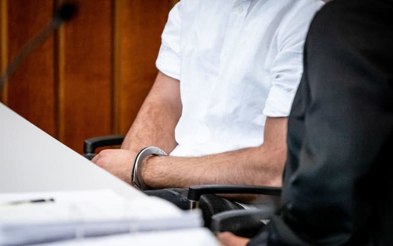 The defendant sits handcuffed in his seat in a courtroom at Heilbronn District Court.  A 21-year-old man has been sentenced to nine years in prison for causing a fatal accident while driving at high speed in the centre of Germany's southern city of Heilbronn. Christoph Schmidt/dpa