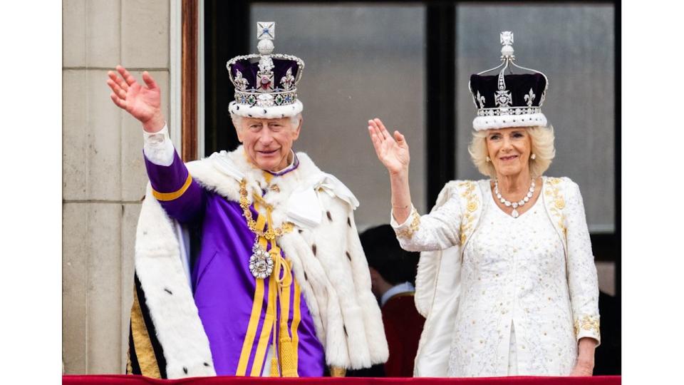 King Charles and Queen Camilla waving from palace balcony on coronation day