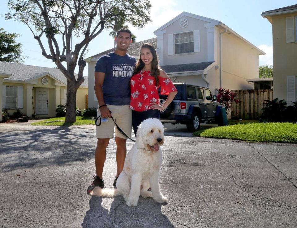 Jhon Ospina and his wife, Angela Ospina, stand outside their Kendall home with their dog, Marley, on Feb. 15, 2020. The couple used a military veteran no-down-payment loan to buy their home.