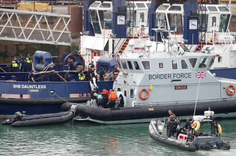 Migrants disembark from a Border Force boat after arriving at Dover harbour, in Dover