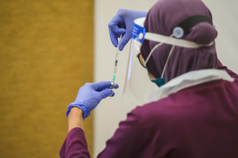 A health worker prepares a dose of the Covid-19 vaccine at the Eastin Hotel, Petaling Jaya July 23, 2021. — Picture by Shafwan Zaidon