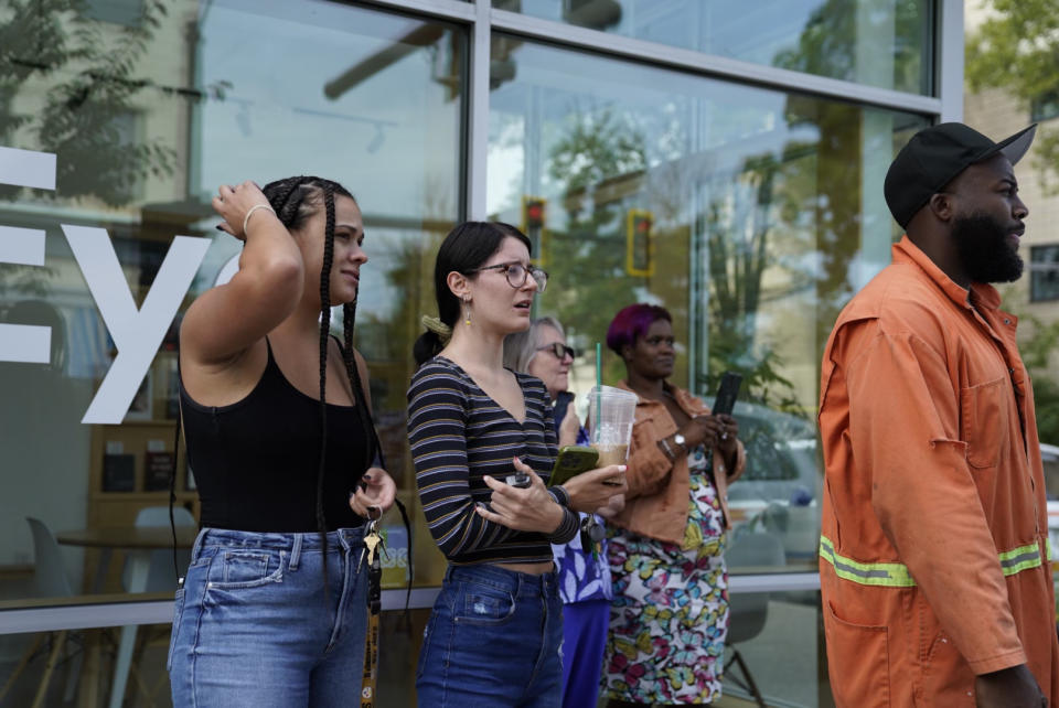 Bystanders watch as Pittsburgh police and other law enforcement personal respond to gunfire in the Garfield neighborhood of Pittsburgh on Wednesday, Aug. 23, 2023. (Benjamin B. Braun/Pittsburgh Post-Gazette via AP)