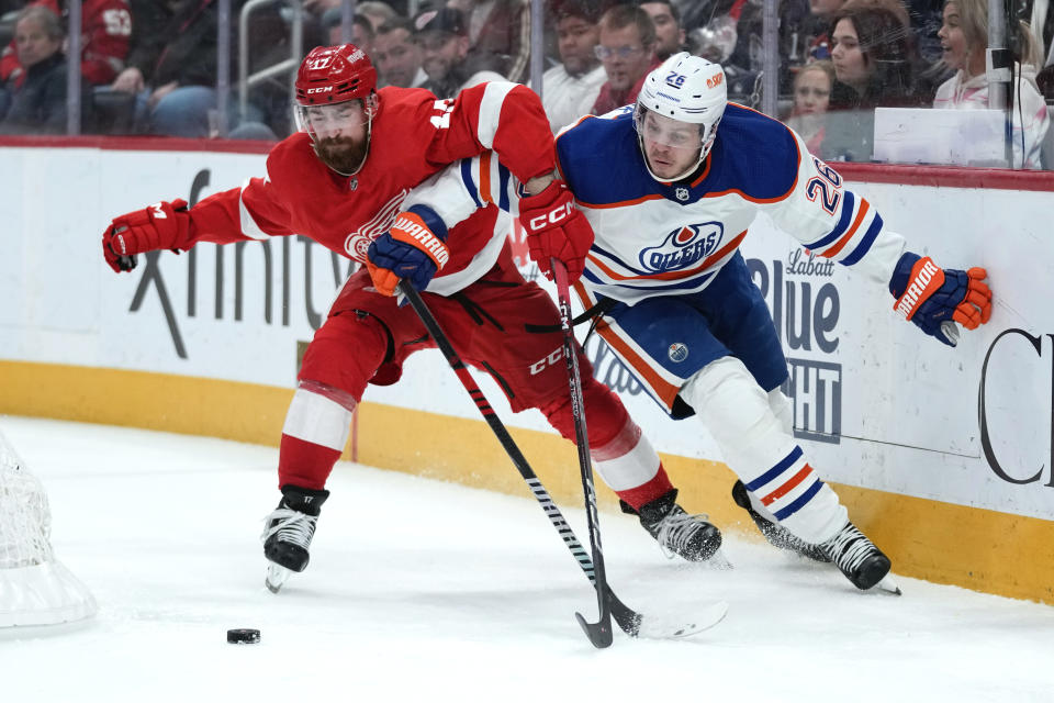 Detroit Red Wings defenseman Filip Hronek (17) and Edmonton Oilers center Mattias Janmark (26) battle for the puck in the third period of an NHL hockey game Tuesday, Feb. 7, 2023, in Detroit. (AP Photo/Paul Sancya)