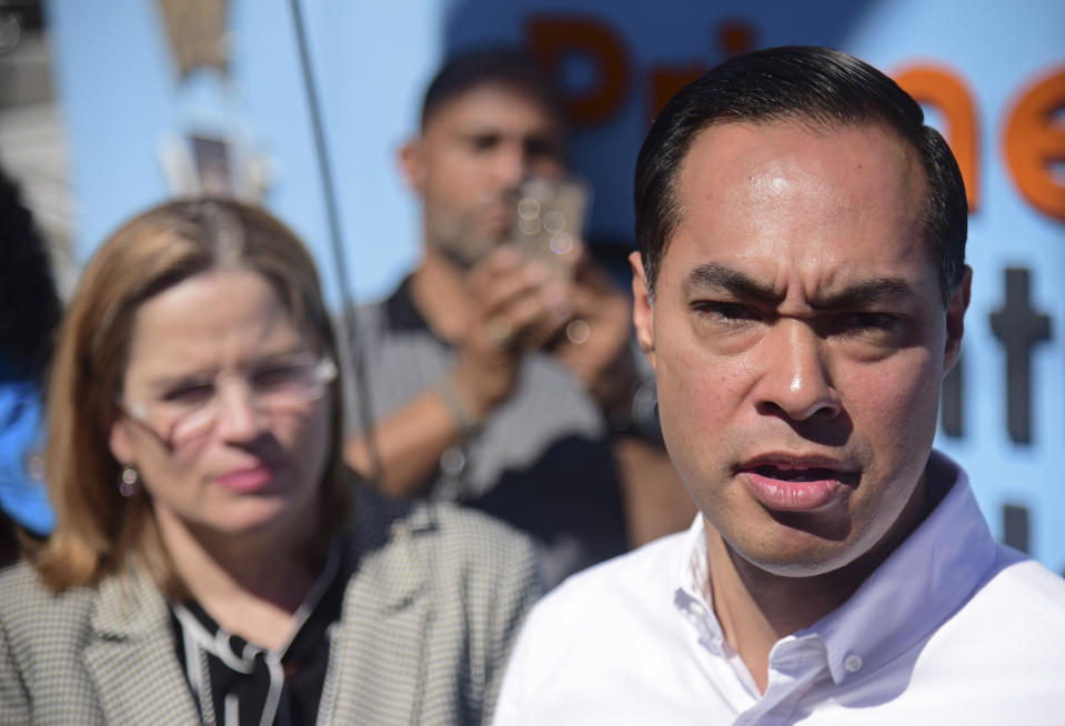 Julian Castro speaks to the press in Playita, one of the poorest and most affected communities by Hurricane Maria, as San Juan Mayor Carmen Yulin Cruz Soto stands behind him in San Juan, Puerto Rico, Monday, Jan. 14, 2019. The presidential candidate has joined dozens of high-profile Latinos in Puerto Rico to talk about mobilizing voters ahead of the 2020 elections and increasing Latino political representation to take on President Donald Trump. (AP Photo/Carlos Giusti)