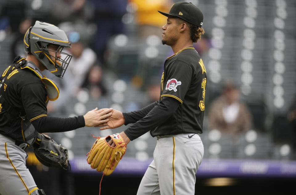Pittsburgh Pirates catcher Jason Delay, left, congratulates relief pitcher Dauri Moreta after the ninth inning of a baseball game against the Colorado Rockies Wednesday, April 19, 2023, in Denver. (AP Photo/David Zalubowski)