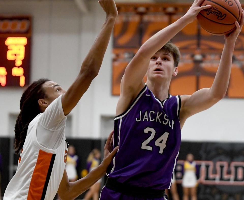 Jackson's Kyle Monterrubio put in two under pressure from Green's Jarrett Taylor in the second quarter of Jackson at Green boys basketball. Friday, December 8, 2023.