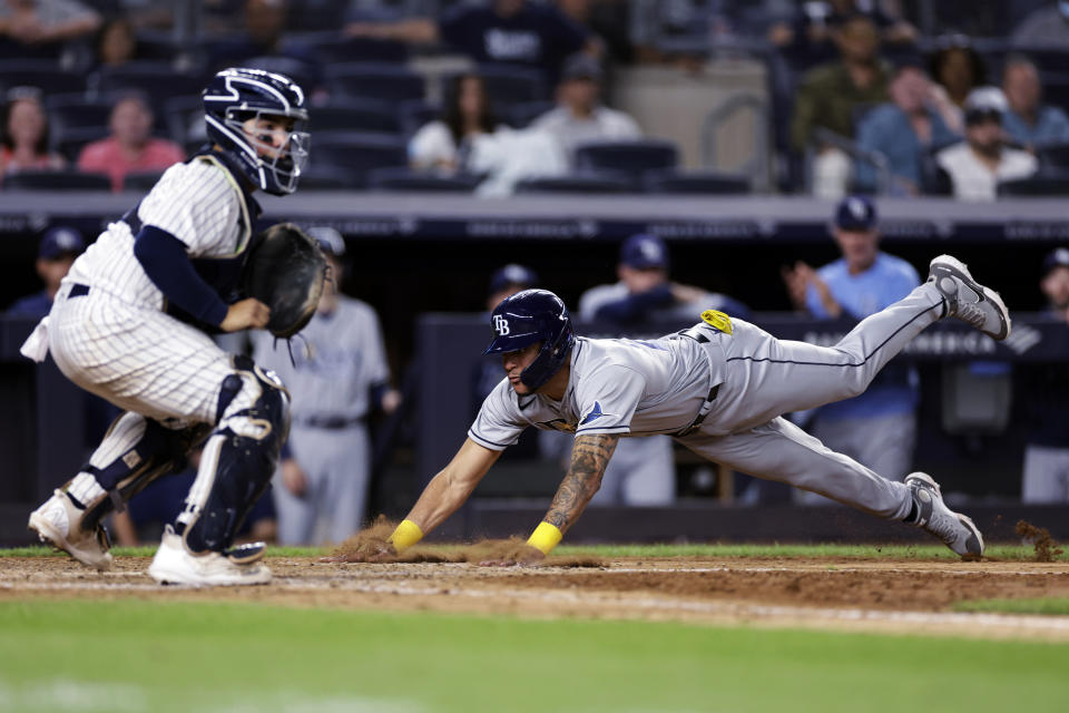 Tampa Bay Rays' Jose Siri scores a run past New York Yankees catcher Jose Trevino during the ninth inning of a baseball game Monday, Aug. 15, 2022, in New York. (AP Photo/Adam Hunger)