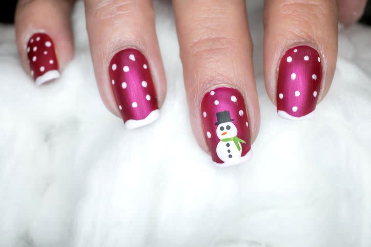 seasonal inspired nail art with pink nails and white snow and a snowman