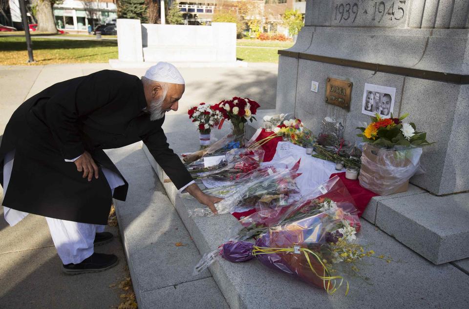 Imam Syed Soharwardy lays flowers at the cenotaph on a Canadian flag laid out for Canadian soldier Cpl. Nathan Cirillo at Central Memorial park in Calgary, Alberta, October 24, 2014. The Muslims Against Terrorism and Islamic Supreme Council of Canada were holding a memorial service in the city for the two Canadian soldiers killed this past week. REUTERS/Todd Korol (CANADA - Tags: CIVIL UNREST CRIME LAW MILITARY RELIGION POLITICS)