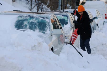 A woman digs out her car following winter snow storm Grayson in Boston, Massachusetts, U.S., January 5, 2018. REUTERS/Brian Snyder