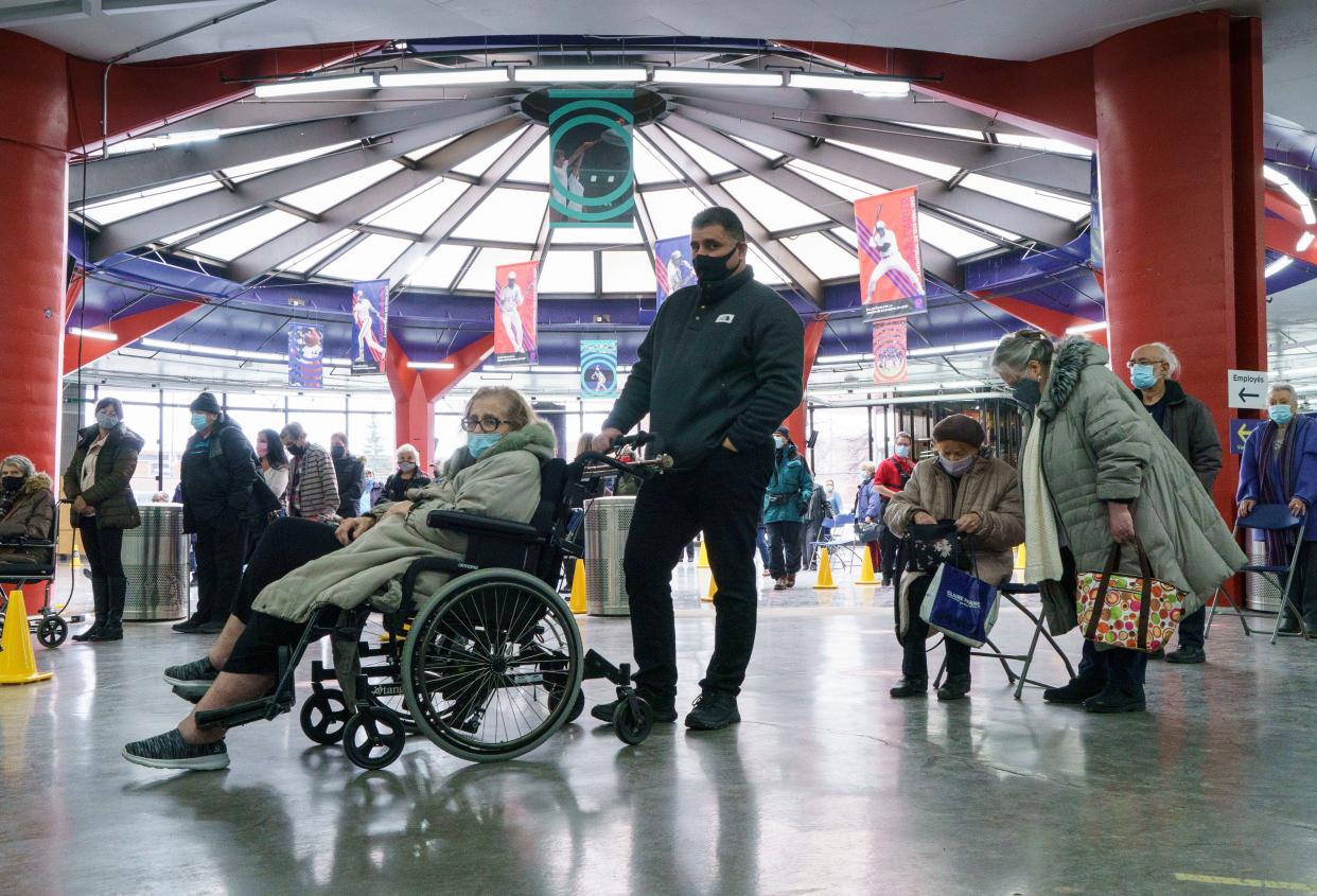 People wait in line at a COVID-19 vaccine clinic at Olympic Stadium marking the beginning of mass vaccination in the Province of Quebec based on age in Montreal on Monday, March 1, 2021.