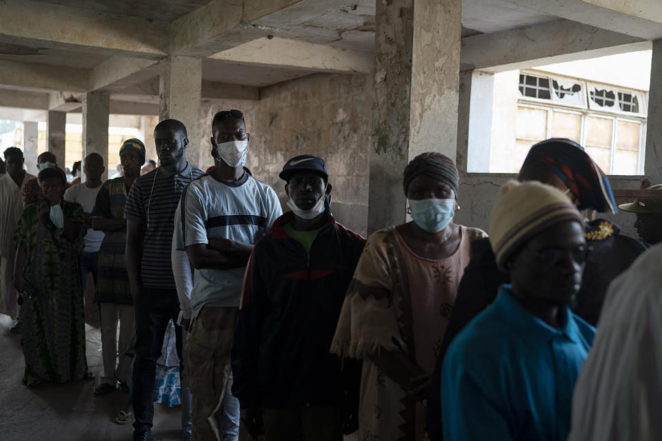 People line up to cast their ballot for Gambia's presidential elections, in Banjul, Gambia, Saturday, Dec. 4, 2021. Lines of voters formed outside polling stations in Gambia’s capital as the nation holds a presidential election. The election on Saturday is the first in decades without former dictator Yahya Jammeh as a candidate. (AP Photo/Leo Correa)