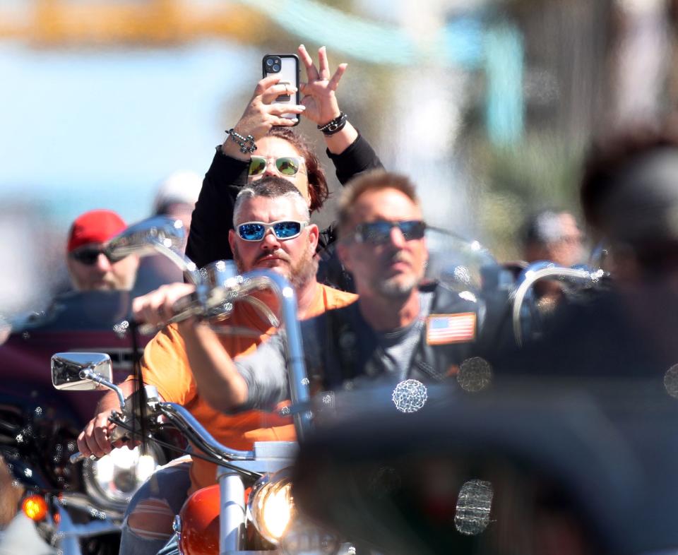 A rider takes cellphone video while cruising Main Street during the closing weekend of Bike Week 2023. The 10-day event unfolded under weather that was mostly picture-perfect for riding.