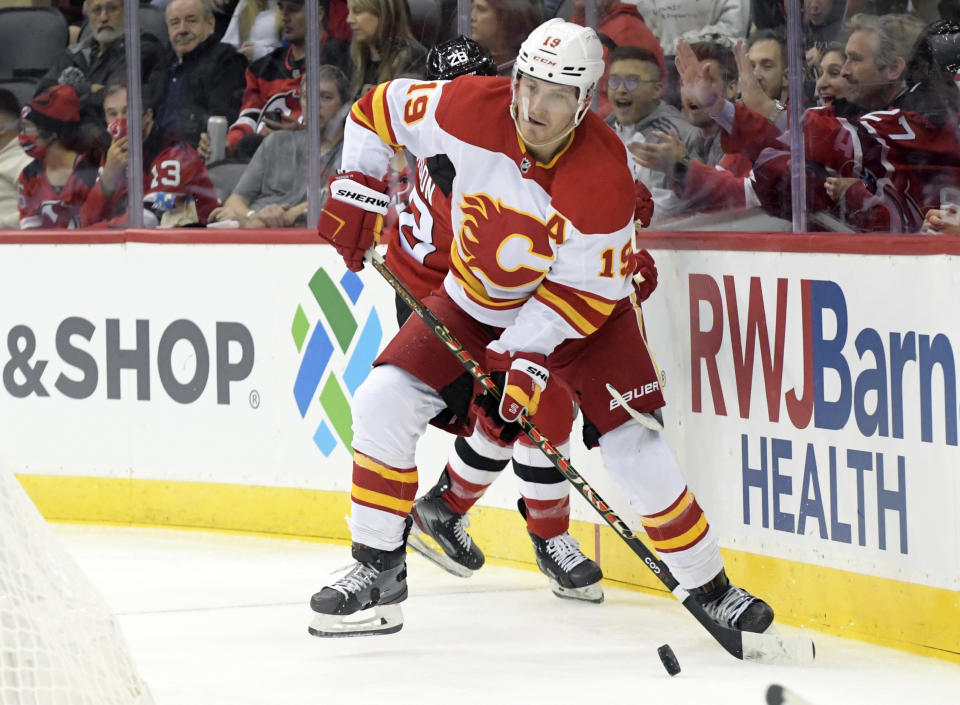 Calgary Flames left wing Matthew Tkachuk (19) looks to pass the puck during the second period of an NHL hockey game against the New Jersey Devils Tuesday, Oct. 26, 2021, in Newark, N.J. (AP Photo/Bill Kostroun)