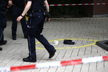 A police officer walks past crime scene after a knife attack in a supermarket in Hamburg, Germany. One person was killed and several were injured in an attack by a lone knifeman in a supermarket in the northern German city on Friday, police said. REUTERS/Morris Mac Matzen