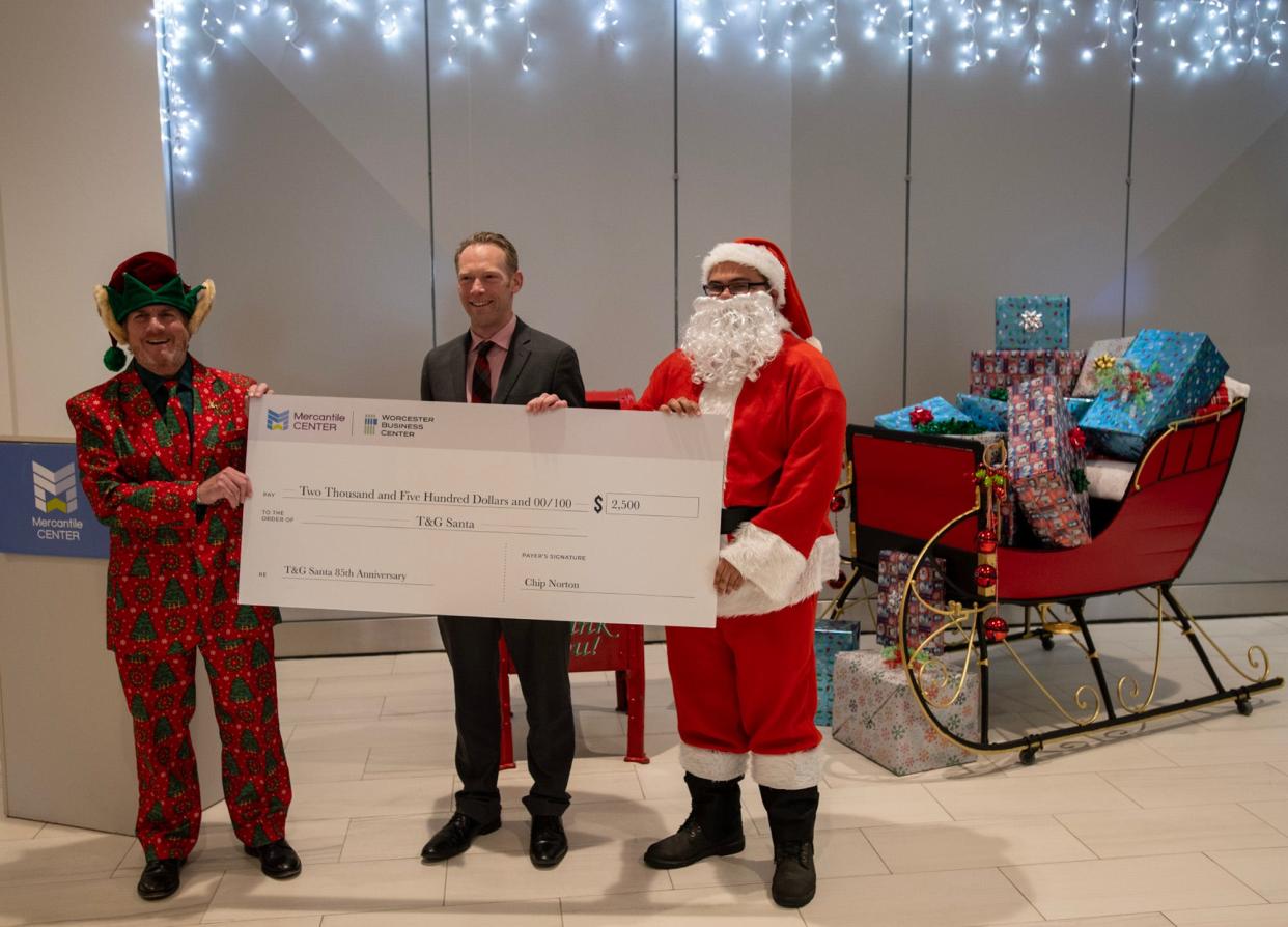 Charles “Chip” Norton Jr. and Michael McDermott join Santa Claus in the lobby of Mercantile Center Wednesday.