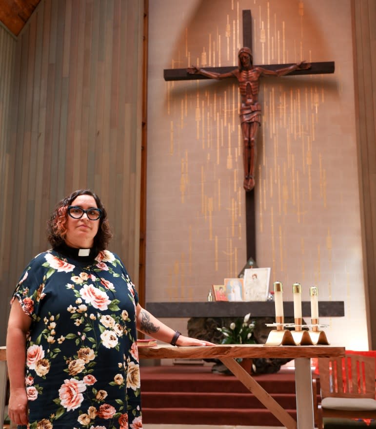 The Rev. Miranda Hasset stands before the altar of the St. Dunstan’s Episcopal Church in Madison, Wis. The church paid $4,000 for its use of land formerly belonging to the Ho-Chunk Nation. “We acknowledge that our ability to worship on Ho-Chunk land came at a great cost to those people,” Hassett says. Taken Aug. 26, 2022. (Amena Saleh / Wisconsin Watch)