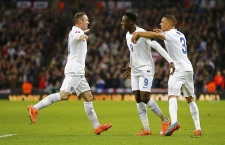 England captain Wayne Rooney (L) celebrates with teammates Danny Welbeck and Kieran Gibbs (R) after scoring from a penalty kick during their Euro 2016 Group E qualifying soccer match against Slovenia at Wembley Stadium in London November 15, 2014. REUTERS/Darren Staples