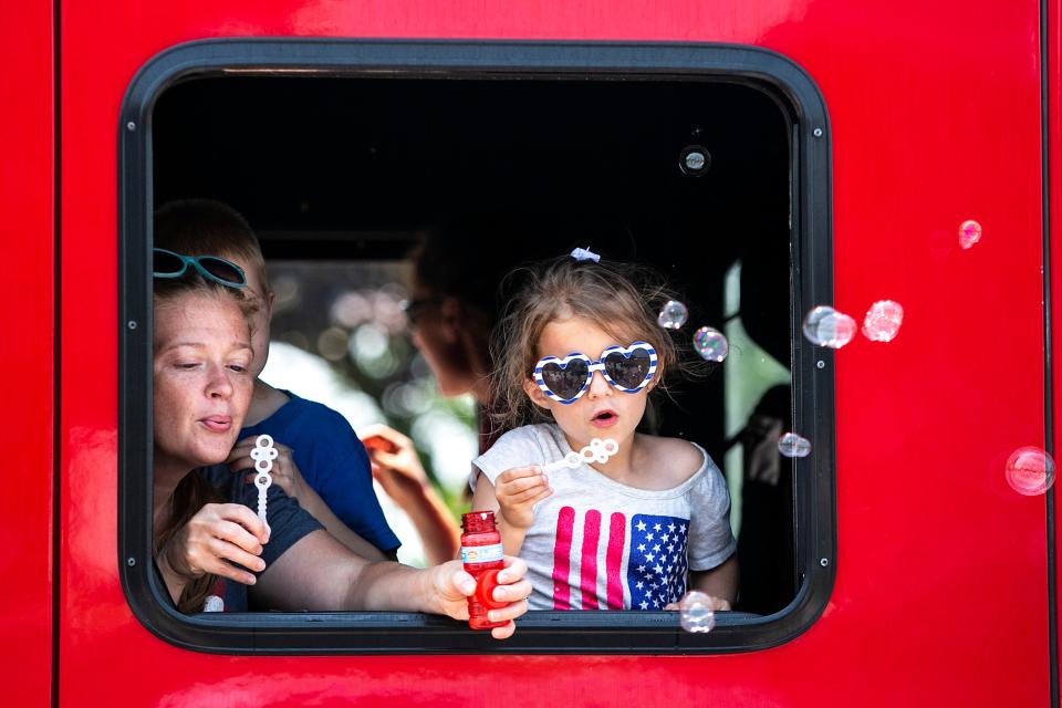 A girl blows bubbles as thousands enjoy the 4thFest parade on Independence Day, Sunday, July 4, 2021, in Coralville, Iowa.