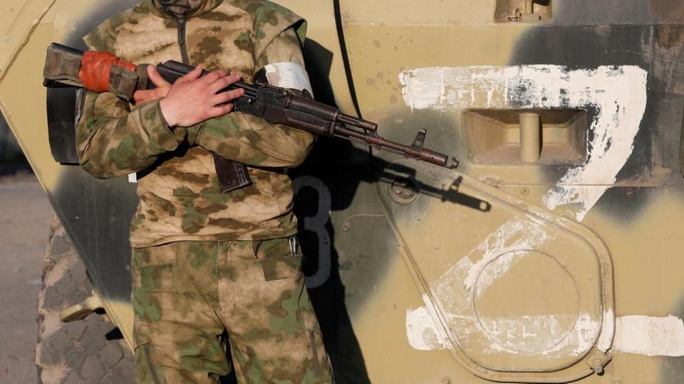Un soldado ruso parado junto al símbolo Z, a favor de Rusia.
