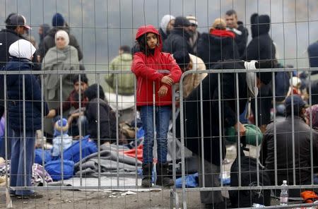 A migrant girl waits to enter a makeshift camp at the Austrian Slovenian border near the village of Sentilj, Slovenia, October 26, 2015. REUTERS/Leonhard Foeger