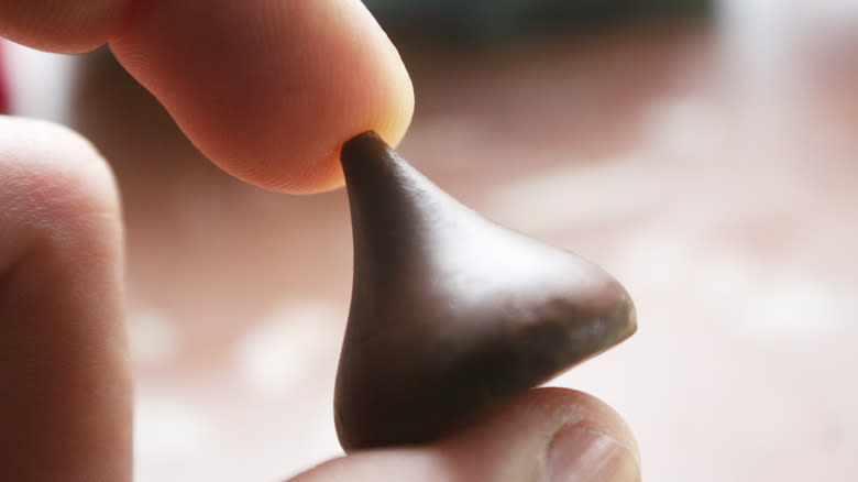 hand holding Hershey's kiss