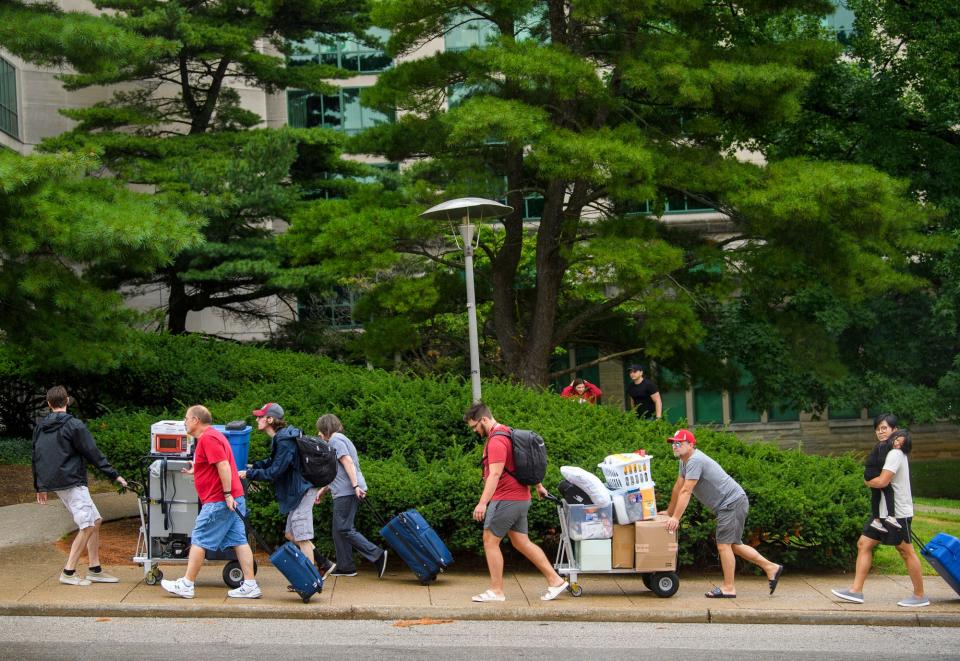 Students family and friends carry belongings past Eigenmann Hall during the first day of Welcome Week at Indiana University Sunday, Aug. 14, 2022.