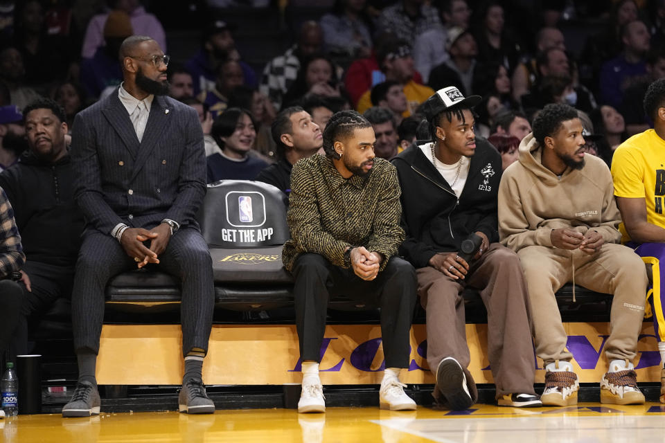 Los Angeles Lakers' LeBron James, left, sits on the bench with D'Angelo Russell, second from left, Jarred Vanderbilt, second from right, and Malik Beasley during the second half of an NBA basketball game against the Milwaukee Bucks Thursday, Feb. 9, 2023, in Los Angeles. (AP Photo/Mark J. Terrill)