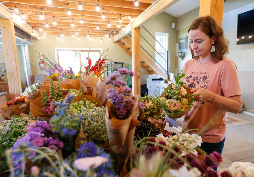 Floral shop owner and flower farmer Cherrelle Hitchcock picks out some flowers available at the Missouri Flower Exchange on Wednesday, June 28, 2023.