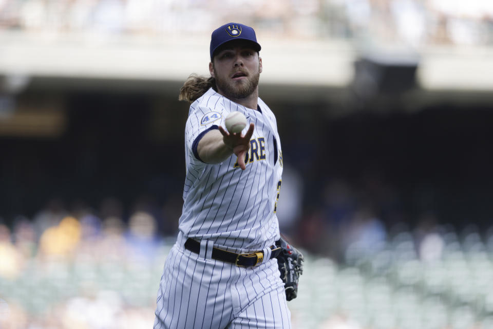 Milwaukee Brewers starting pitcher Corbin Burnes throws to first for an out against Colorado Rockies' Raimel Tapia during the first inning of a baseball game Friday, June 25, 2021, in Milwaukee. (AP Photo/Jeffrey Phelps)