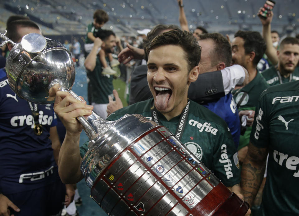 Raphael Veiga of Brazil's Palmeiras holds the trophy as he celebrates with teammates after winning the Copa Libertadores final soccer match against Brazil's Santos at the Maracana stadium in Rio de Janeiro, Brazil, Saturday, Jan. 30, 2021. Palmeiras won 1-0.(Ricardo Moraes/Pool via AP)