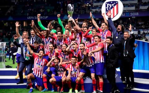 Atletico's players celebrate with the trophy - Credit: GEtty images