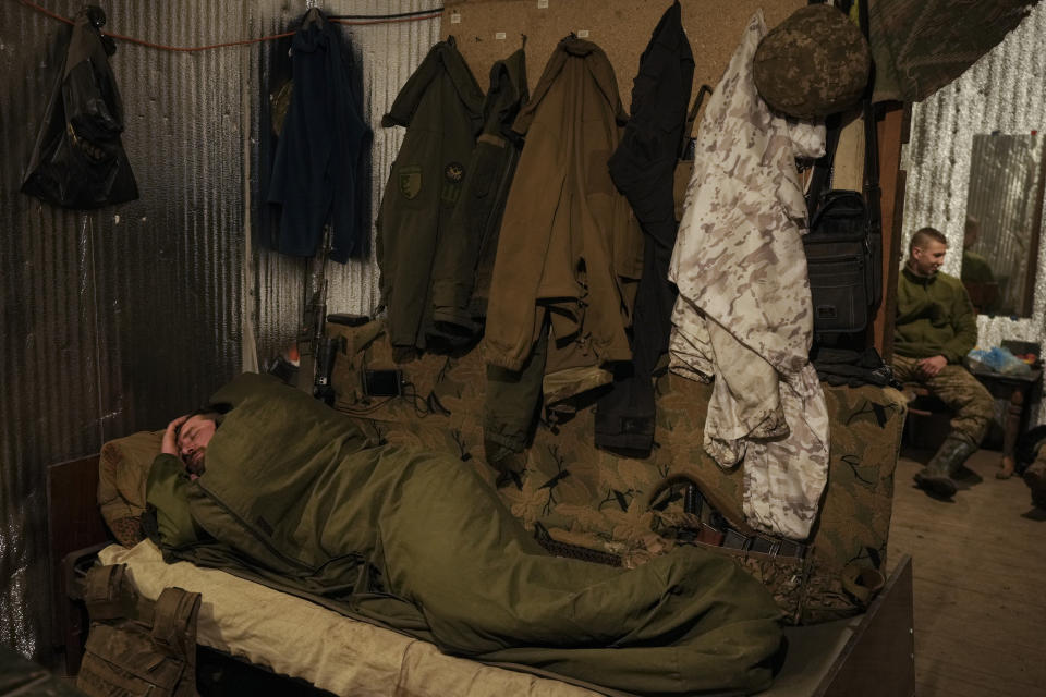 A Ukrainian serviceman sleeps after his shift at a frontline position outside Popasna, in the Luhansk region, eastern Ukraine, Sunday, Feb. 20, 2022. Russia extended military drills near Ukraine's northern borders Sunday amid increased fears that two days of sustained shelling along the contact line between soldiers and Russia-backed separatists in eastern Ukraine could spark an invasion. Ukraine's president appealed for a cease-fire. (AP Photo/Vadim Ghirda)